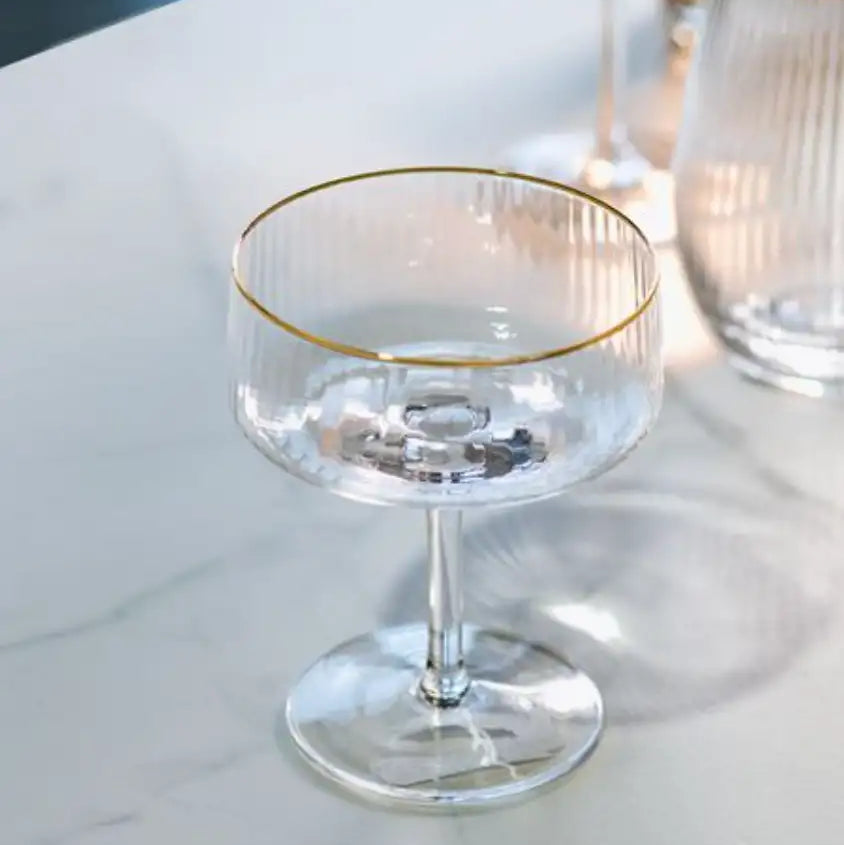 Clear glass with gold rim on a white surface