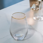 Clear glass with gold rim on a white surface