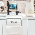 Kitchen counter with a towel labeled 'Home' and a pitcher.