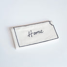 Rectangular white pillow with 'Home' embroidery on a light gray background